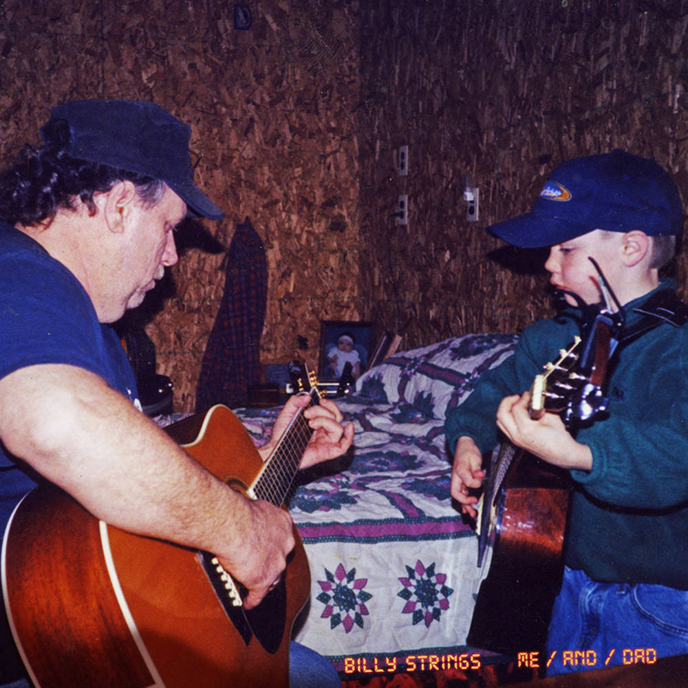 A vinyl record album cover featuring two individuals, presumably Billy Strings and his father, playing guitars and smiling.