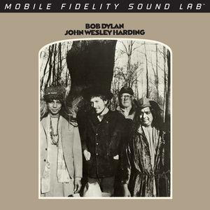 Album cover of 'John Wesley Harding' by Bob Dylan featuring a black and white photo of four people in a forest.