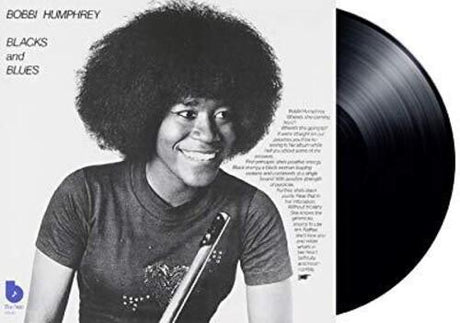 Vinyl record with a person on the cover and text about 'Blacks and Blues'.