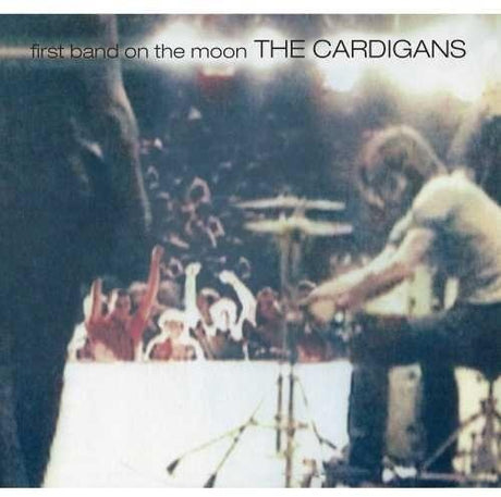 Album cover for The Cardigans' First Band On The Moon featuring a grainy image of a live performance with the band and audience.