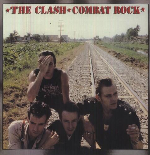 The image shows the cover of the 'Combat Rock' album by The Clash. It features a photograph of the band members sitting or lying on a railway track, with a hot, arid landscape in the background.