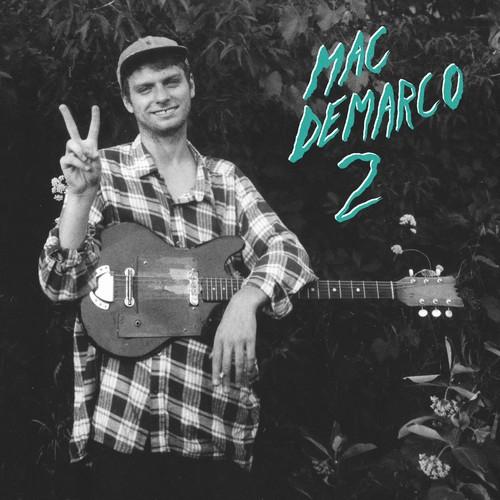 Black and white album cover featuring Mac DeMarco holding a guitar, posing with a peace sign, with the album title '2' prominently displayed.