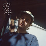 Mac DeMarco wearing a cap, sitting in a vehicle with a blurred background, with the album title 'Salad Days' written above.
