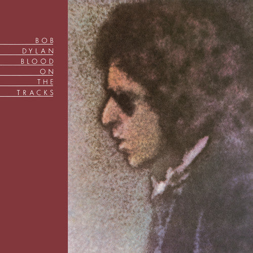 A vinyl record cover featuring a black and white image of Bob Dylan with sunglasses, with the album title 'Blood On The Tracks' written below.