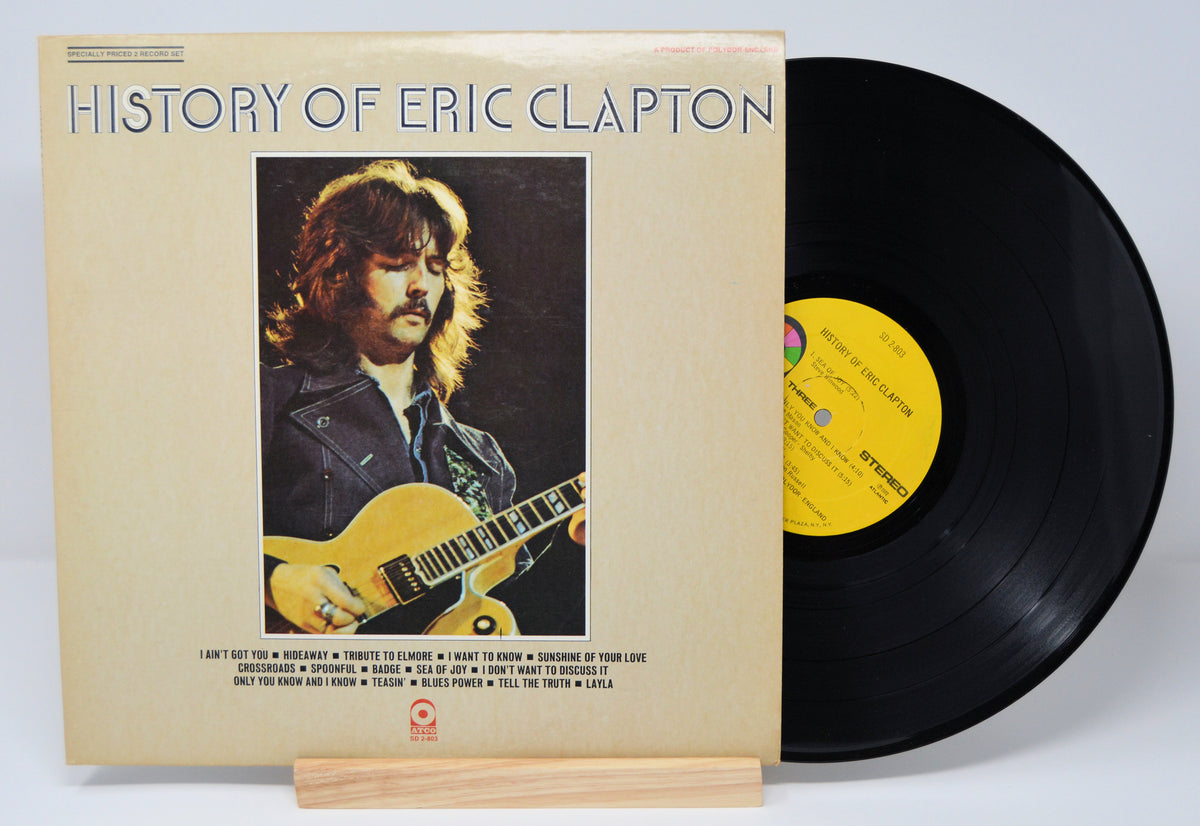 Vinyl record and cover titled 'History of Eric Clapton' on a white background