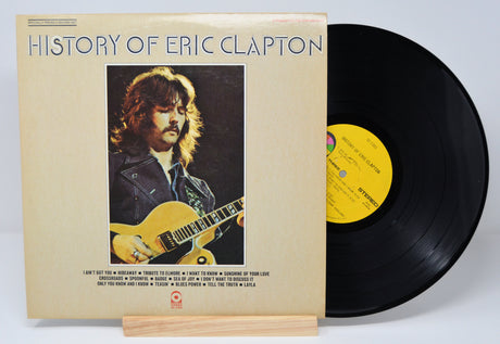 Vinyl record and cover titled 'History of Eric Clapton' on a white background