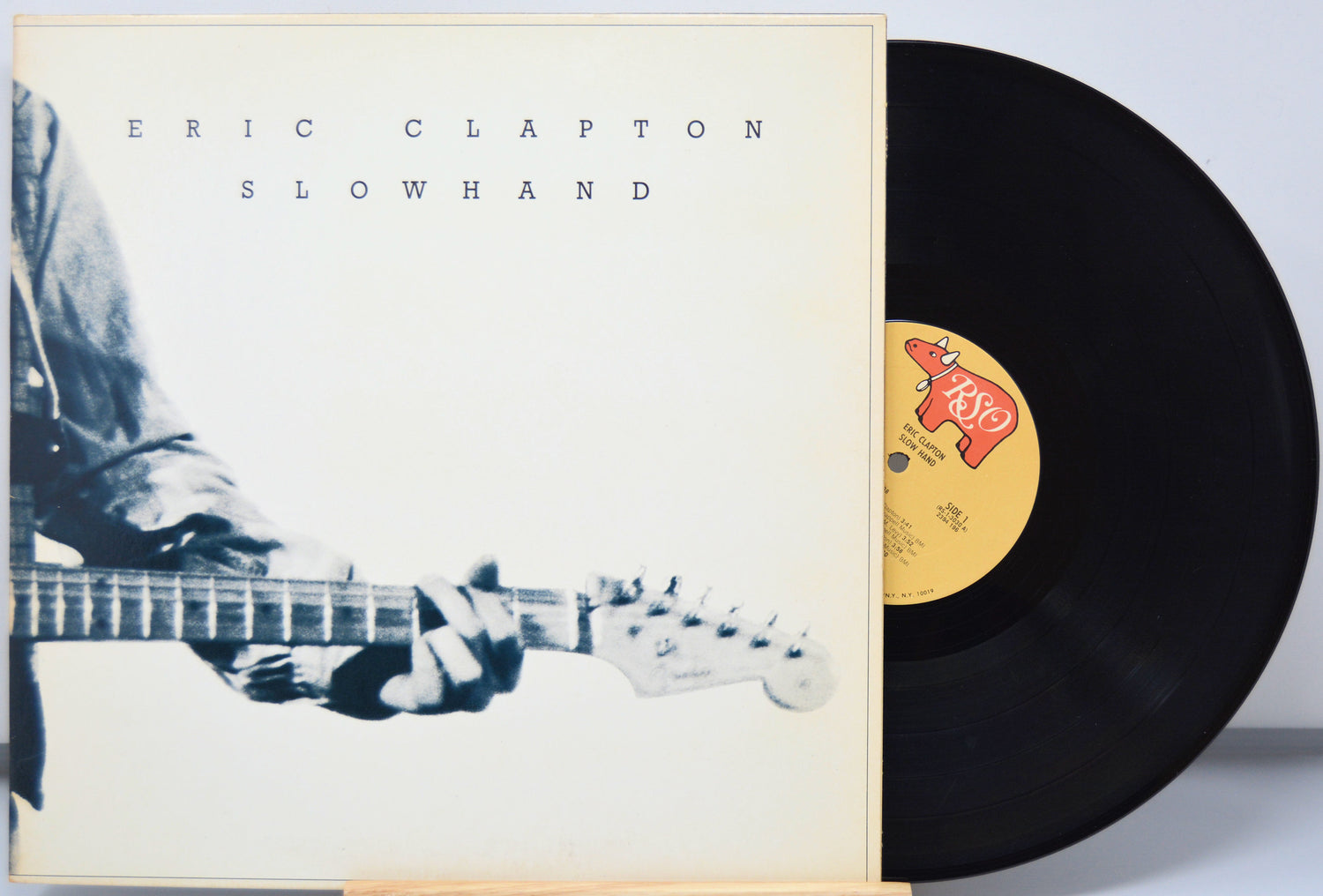 Vinyl record with 'Eric Clapton Slowhand' cover showing a person playing guitar.