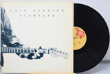 Vinyl record with 'Eric Clapton Slowhand' cover showing a person playing guitar.