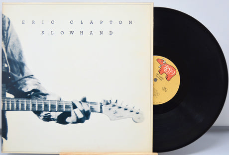 Vinyl record with 'Eric Clapton Slowhand' cover showing a person playing guitar.