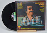 Vinyl record album by Dave Grusin titled Discovered Again showing a picture of him and text listing the song titles on the back cover.