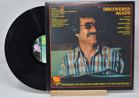 Vinyl record album by Dave Grusin titled Discovered Again showing a picture of him and text listing the song titles on the back cover.