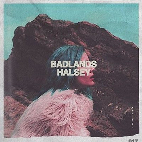 This image features the album cover of "Badlands" by Halsey, a vinyl record representing the artist's debut full-length album. The cover art depicts a enigmatic scene with Halsey partially concealed by a rock formation, adding a sense of mystery and depth.