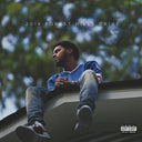A vinyl record album cover featuring J. Cole sitting on a rooftop with a tree in the background.