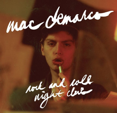 Album cover with a person applying lipstick, featuring the text 'mac deMarco' and 'rock and roll night club'.