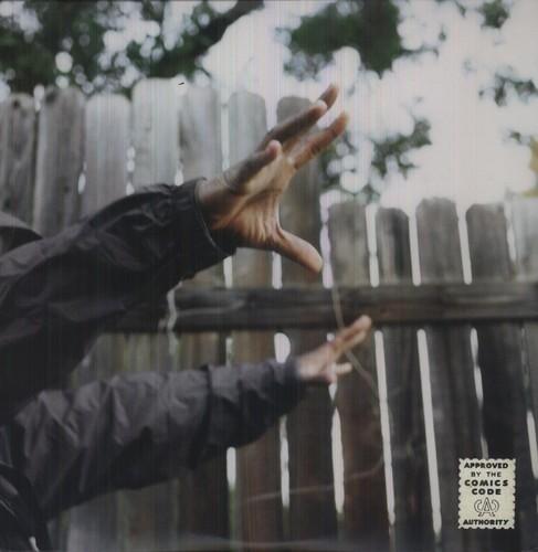 A person's hands reaching towards the sky, with a wooden fence in the background.