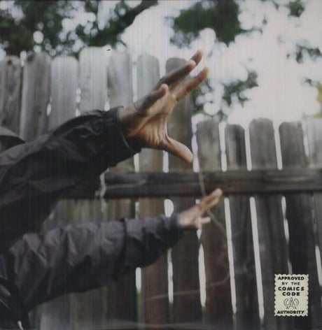 A person's hands reaching towards the sky, with a wooden fence in the background.
