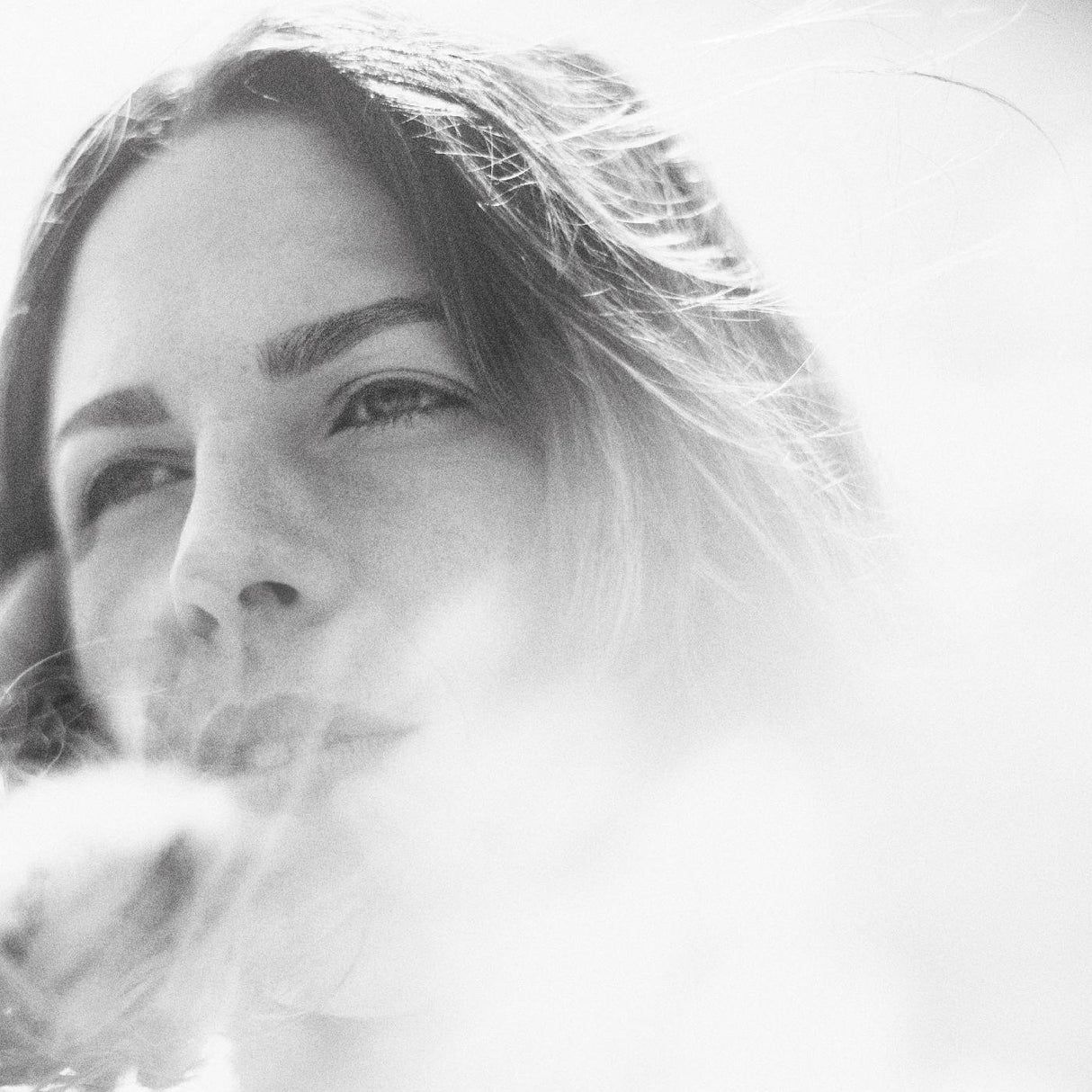 Black and white close-up of a person with smoke in the foreground