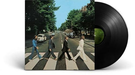 The image shows the album cover of 'The Beatles - Abbey Road' with the iconic photo of the band members crossing a road. A black vinyl record is also visible in the foreground.