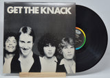 A vinyl record titled 'GET THE KNACK' by The Knack, with a black label and multicolored record.