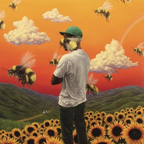 Tyler The Creator - Flower Boy Album cover art for Tyler The Creator - Flower Boy featuring a person with their back turned to the camera wearing a hat, standing in a field of sunflowers with bees and clouds in the sky.