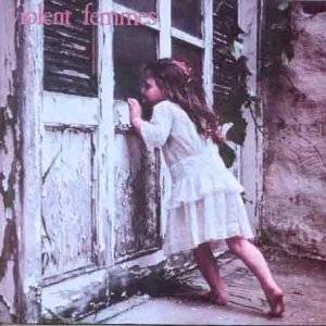 The image features a vinyl record titled "Violent Femmes." The artwork displays a young girl peeking out from behind a window, adding an element of mystery and intrigue.