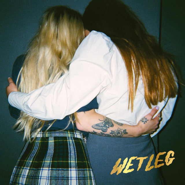 Promotional album cover featuring two individuals embracing, with the band name 'Wet Leg' displayed.