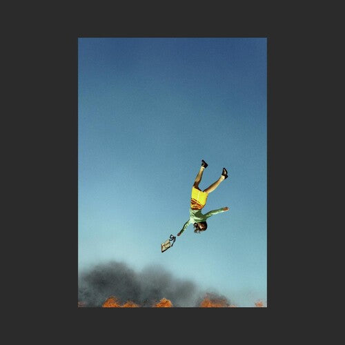 A person in a yellow outfit appears to be floating or falling in the air against a blue sky with clouds and smoke in the background.