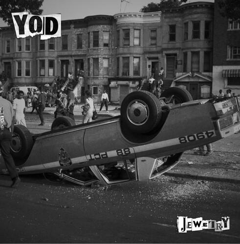 Black and white album cover featuring an upturned car on a street with people in the background, with the artist's name 'YOD' and the album title 'Jewelry' displayed.