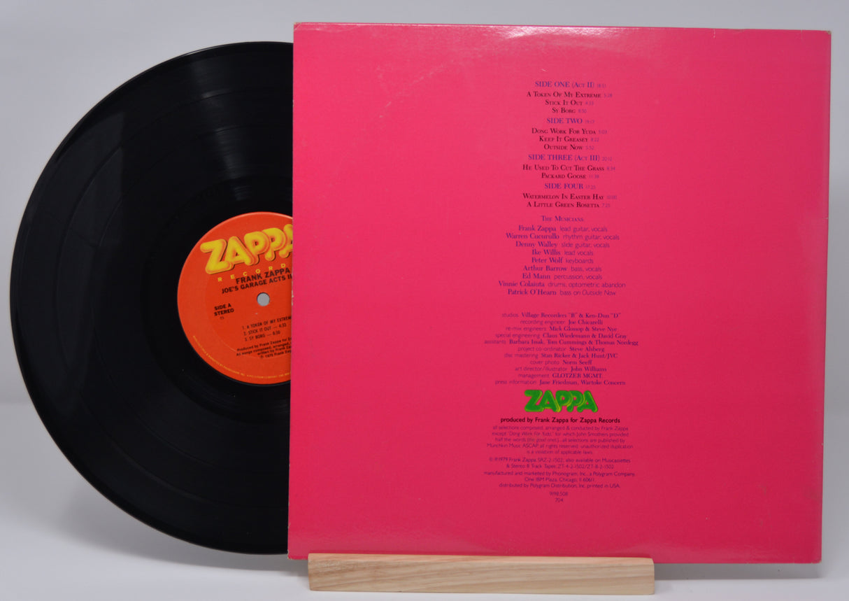 Vinyl record and back cover of 'Frank Zappa - Joe's Garage Acts II III' with text for the song titles and credits