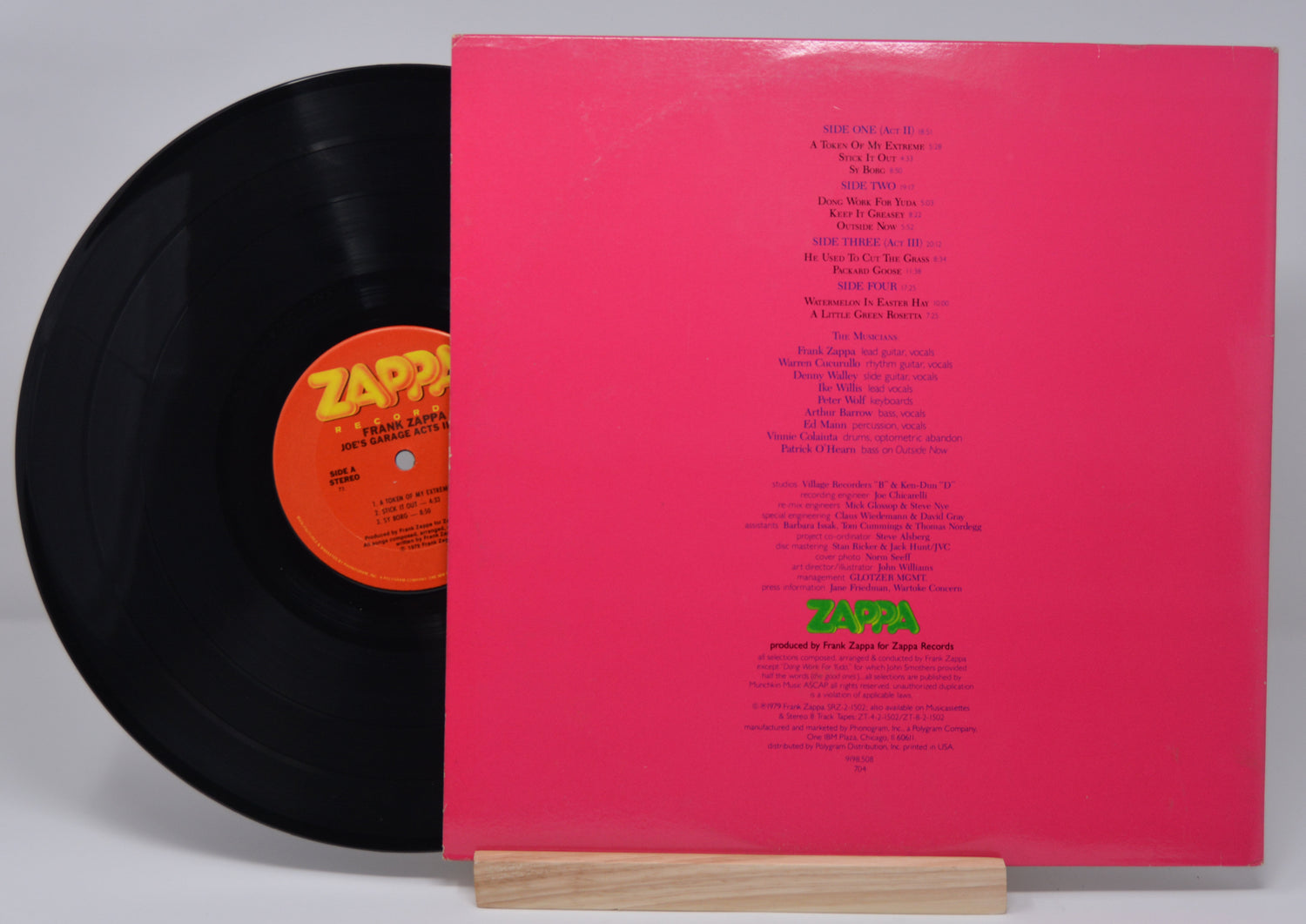 Vinyl record and back cover of 'Frank Zappa - Joe's Garage Acts II III' with text for the song titles and credits