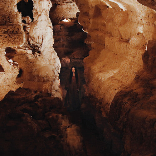 Vinyl record cover for 'Arkhon' by Zola Jesus showing a person standing in a cave-like setting with rock formations and a dark, winding path ahead.