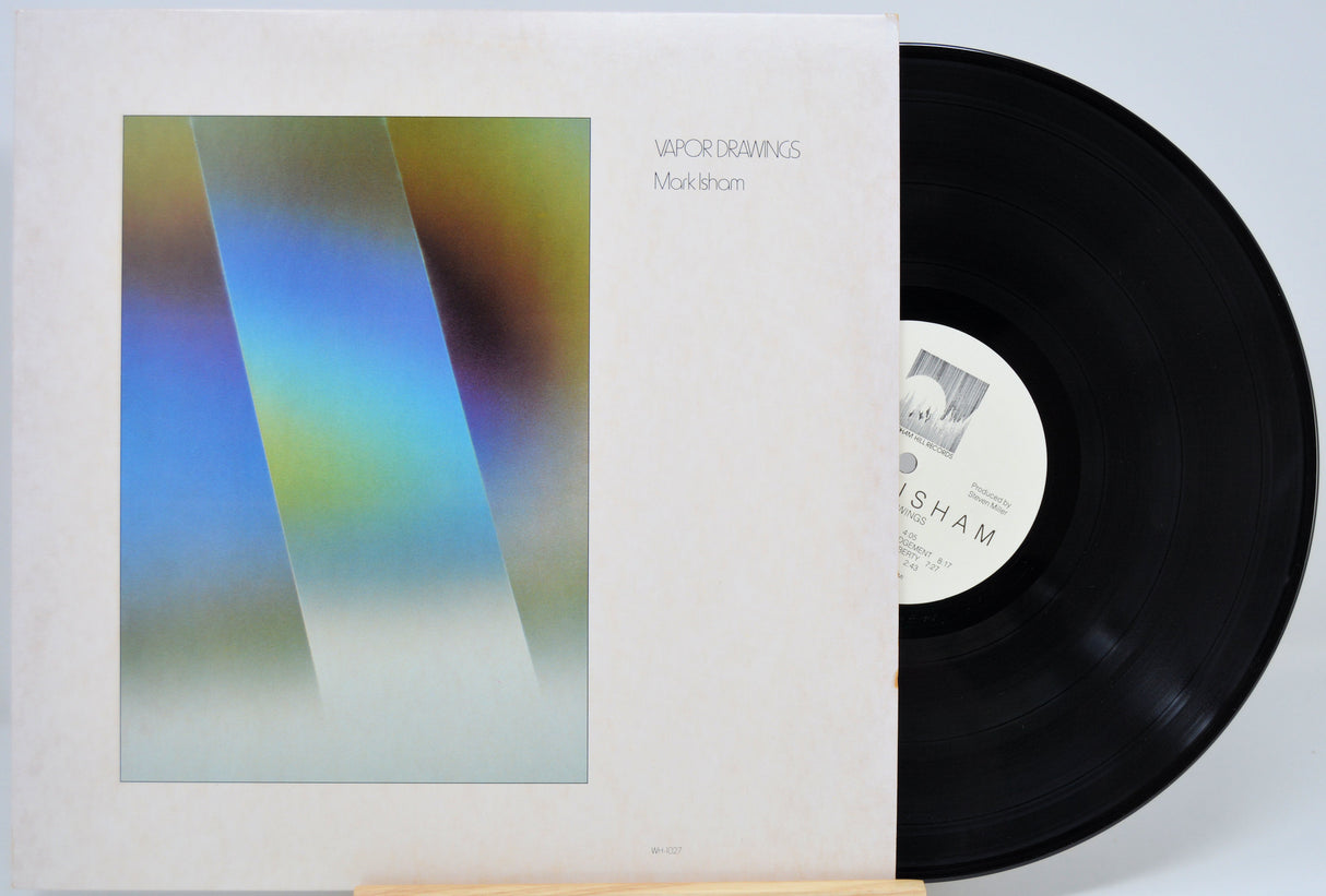 A used vinyl record titled 'Vapor Drawings' by Mark Isham, displayed in its sleeve with the album cover art visible.