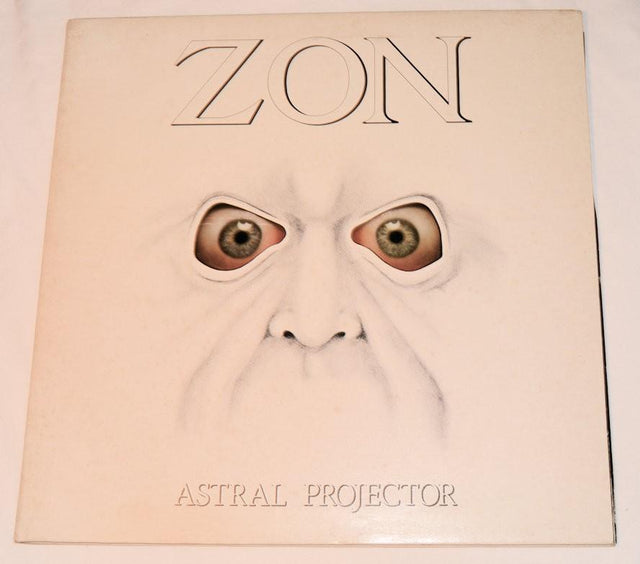 Front vinyl record cover for 'Astral Projector' by Zon showing a drawing of a creepy face with crazy eyes and text of the band name and record title on a  white background.